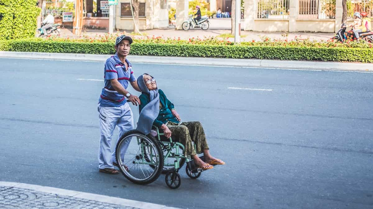 homem empurrando mulher cadeirante