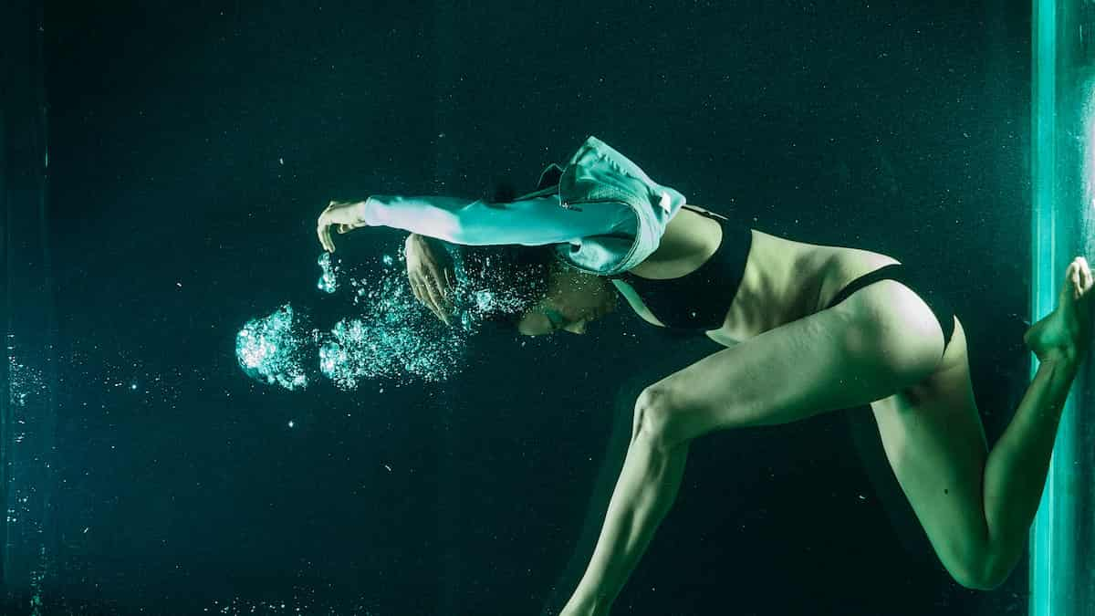 mulher dentro de uma piscina de forma submersa