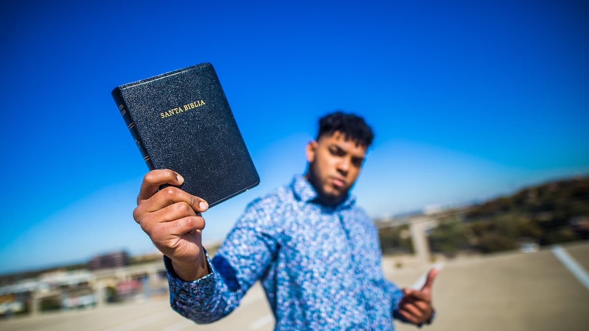 homem segurando a bíblia na mão